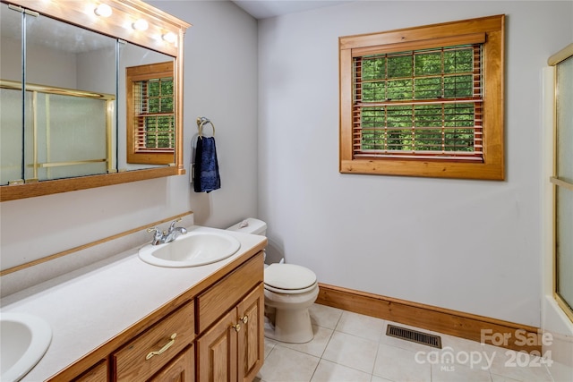 bathroom featuring tile patterned floors, dual vanity, and toilet