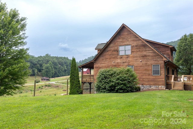 view of property exterior with a wooden deck and a lawn