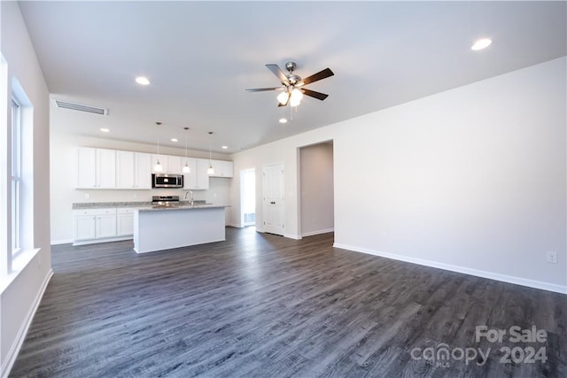 unfurnished living room with dark wood-type flooring, sink, and ceiling fan