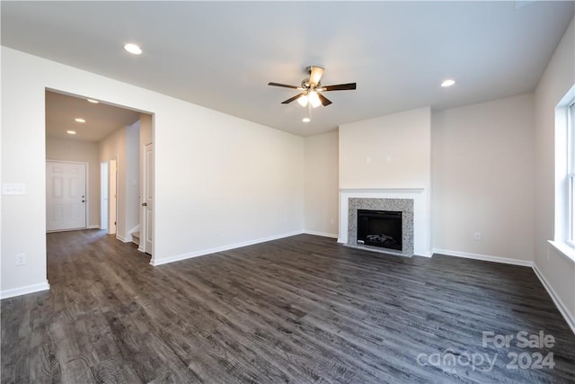 unfurnished living room with ceiling fan and dark wood-type flooring