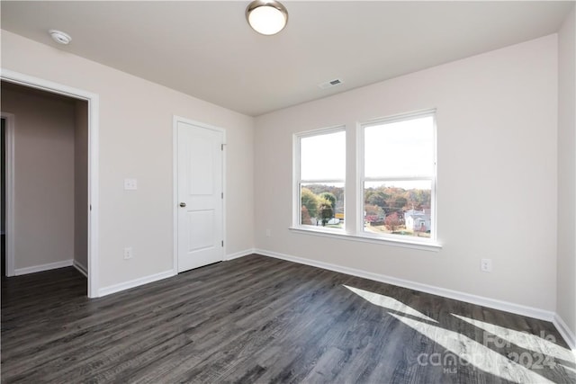 unfurnished bedroom with dark hardwood / wood-style flooring