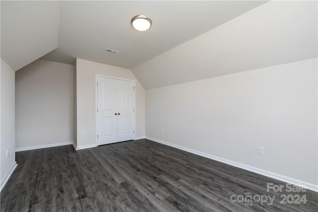 additional living space with dark wood-type flooring and vaulted ceiling