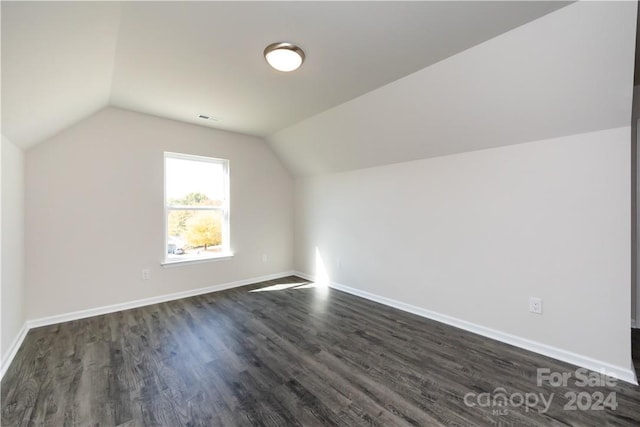 bonus room featuring vaulted ceiling and dark wood-type flooring