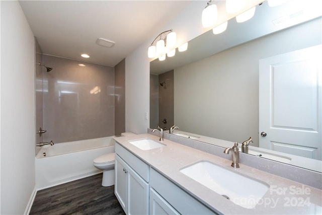 full bathroom with vanity, washtub / shower combination, toilet, and wood-type flooring