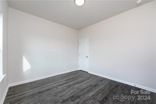 unfurnished room with dark hardwood / wood-style flooring