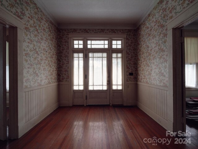 doorway with dark hardwood / wood-style flooring and ornamental molding