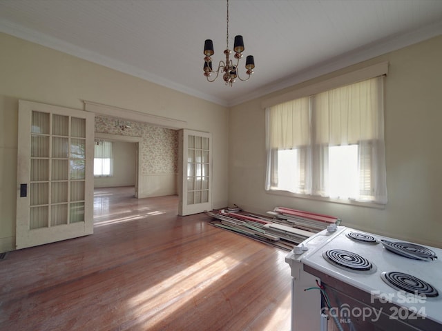 interior space with ornamental molding, french doors, a chandelier, and wood finished floors