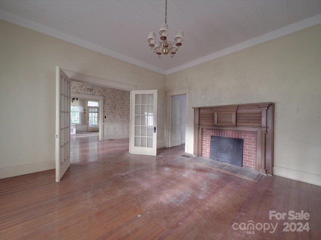 unfurnished living room with french doors, a fireplace, ornamental molding, wood finished floors, and baseboards