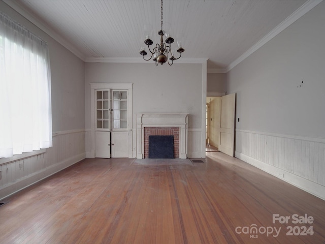 unfurnished living room featuring wainscoting, plenty of natural light, and wood finished floors