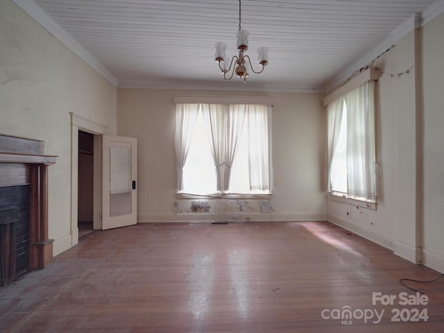 interior space featuring crown molding, a fireplace with flush hearth, wood finished floors, a chandelier, and baseboards