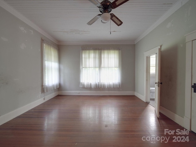 unfurnished room with ornamental molding, a wealth of natural light, and wood finished floors