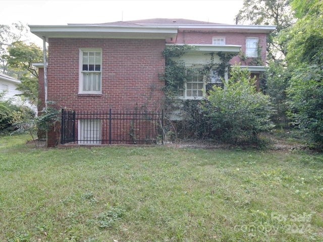 exterior space featuring brick siding and a yard