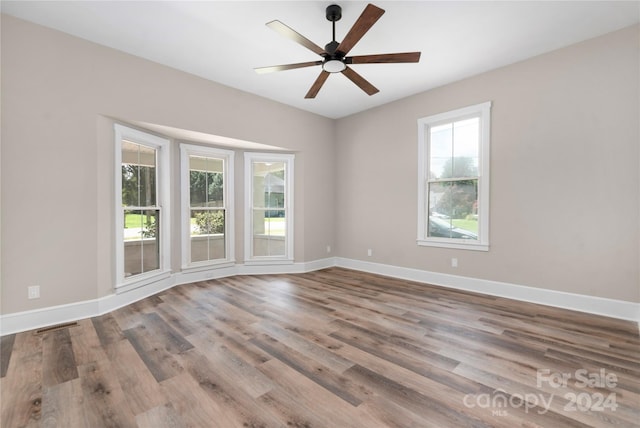 empty room with ceiling fan and hardwood / wood-style flooring