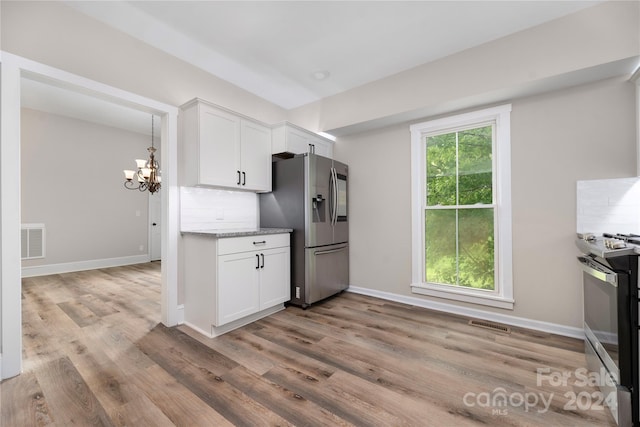 kitchen featuring backsplash, stainless steel appliances, and light wood-type flooring