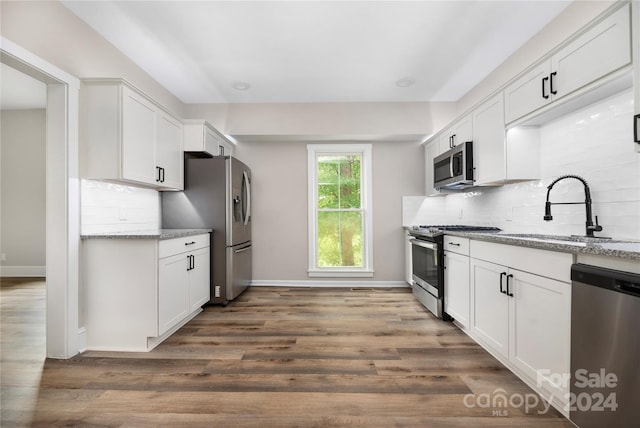 kitchen featuring sink, white cabinetry, hardwood / wood-style floors, and stainless steel appliances