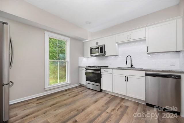 kitchen featuring sink, stainless steel appliances, light hardwood / wood-style floors, and a healthy amount of sunlight