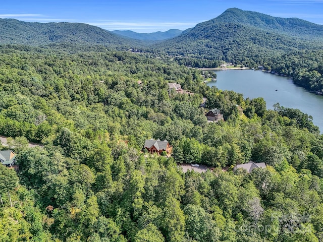 drone / aerial view with a forest view and a water and mountain view