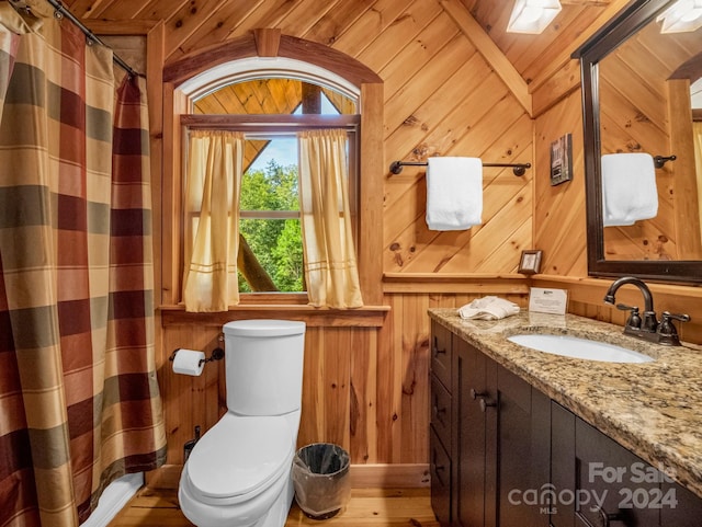 full bathroom with a shower with shower curtain, toilet, wood finished floors, vanity, and wood walls