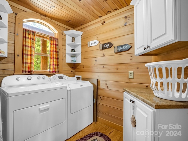 laundry room featuring wood walls, wood ceiling, light wood-style floors, washer and dryer, and cabinet space