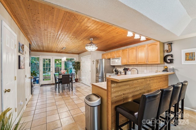 kitchen featuring decorative backsplash, wooden ceiling, light tile patterned floors, kitchen peninsula, and white appliances