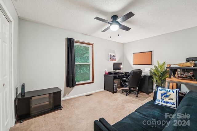 office featuring ceiling fan, light carpet, and a textured ceiling