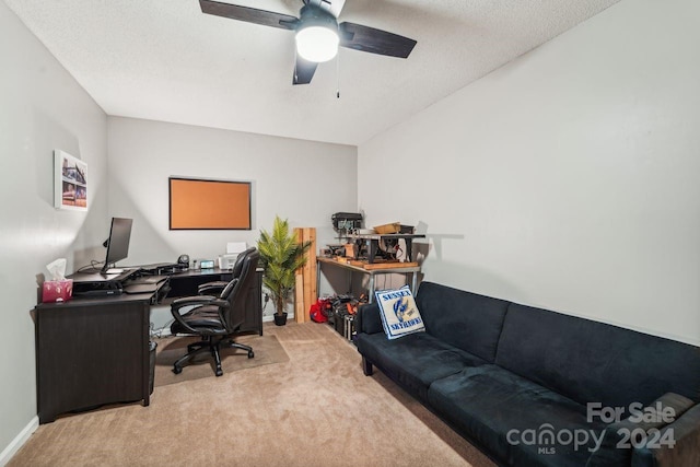 carpeted home office featuring a textured ceiling and ceiling fan