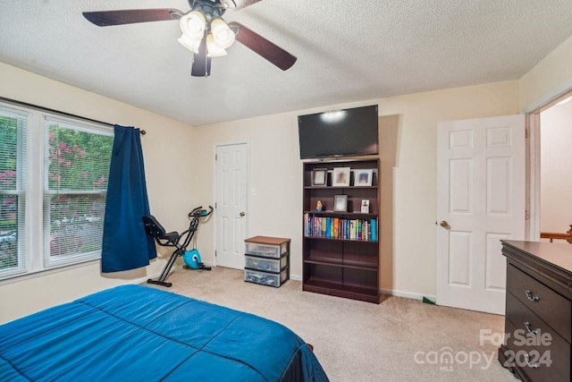 carpeted bedroom featuring a textured ceiling and ceiling fan