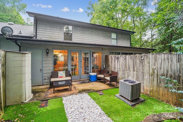 rear view of property with a patio, a yard, central AC unit, and french doors