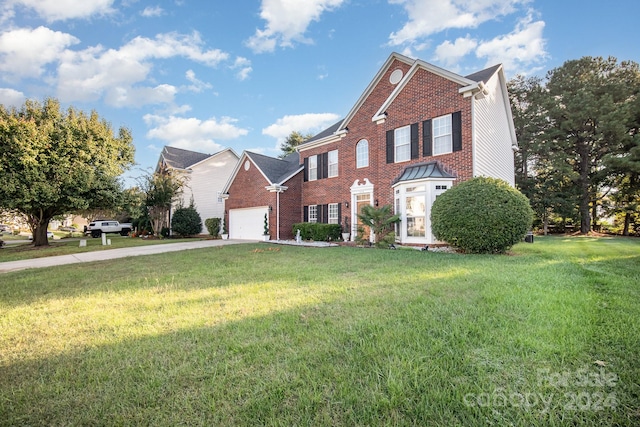 view of property with a garage and a front lawn