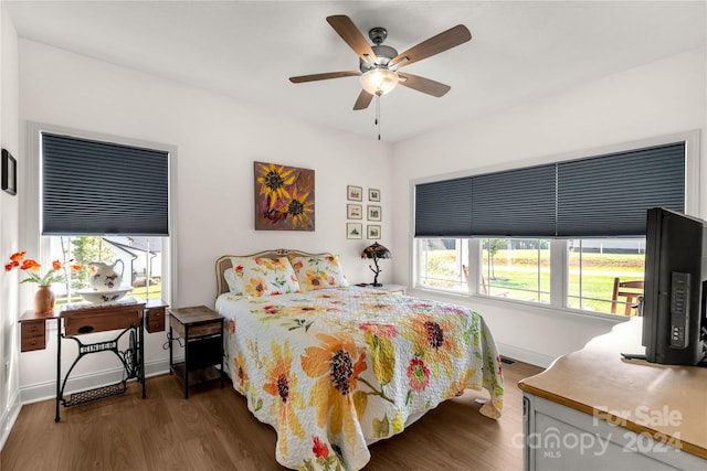 bedroom with dark hardwood / wood-style flooring, multiple windows, and ceiling fan