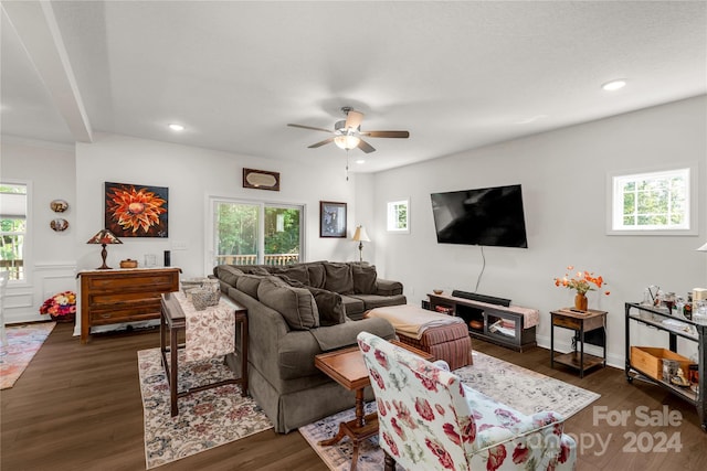 living room with ceiling fan and dark wood-type flooring