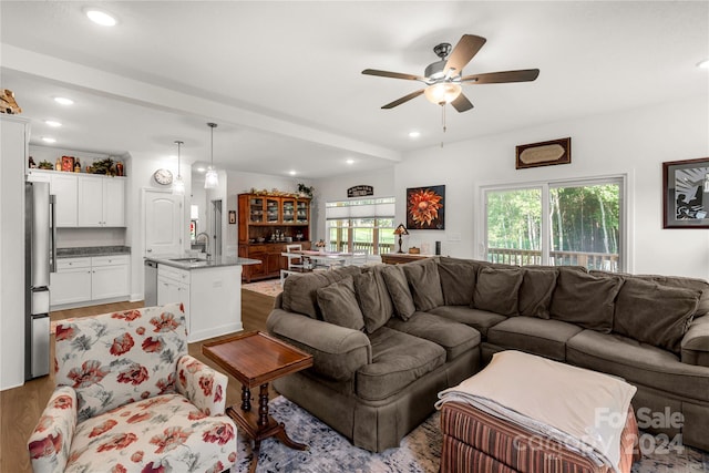 living room with ceiling fan, sink, and light hardwood / wood-style flooring