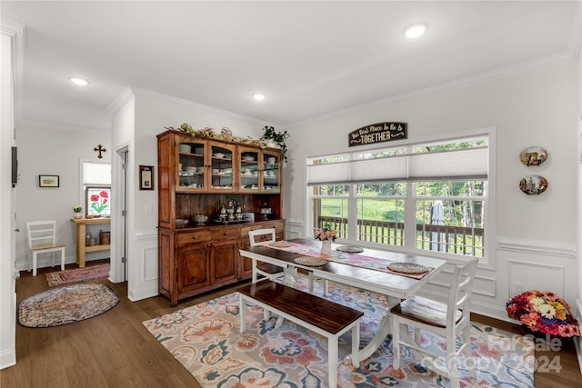 dining area with hardwood / wood-style floors and crown molding