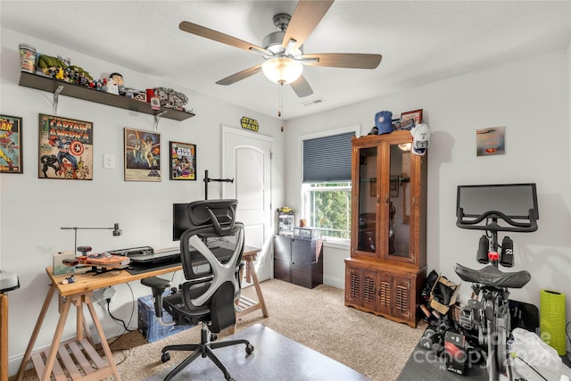 carpeted office featuring ceiling fan