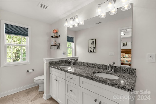 bathroom with tile patterned floors, ceiling fan, double vanity, and toilet