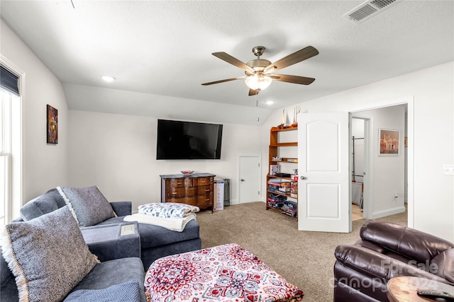 carpeted living room featuring ceiling fan and a textured ceiling