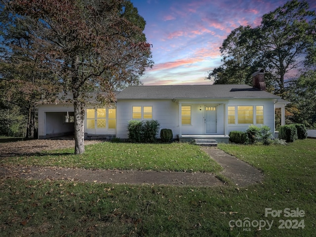 ranch-style home with a lawn