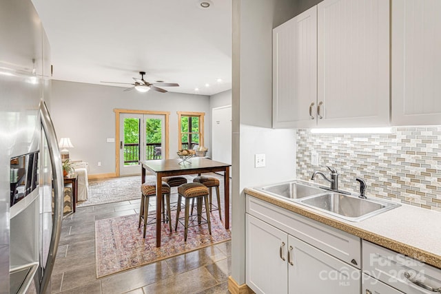 kitchen with white cabinetry, appliances with stainless steel finishes, sink, and backsplash