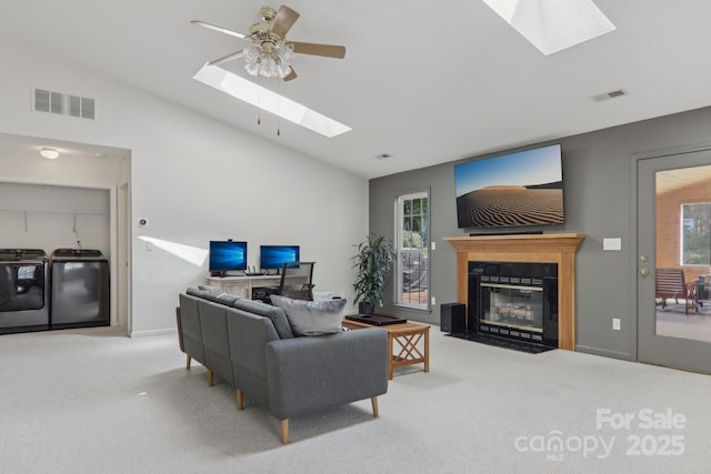 living room featuring separate washer and dryer, ceiling fan, lofted ceiling, and carpet flooring