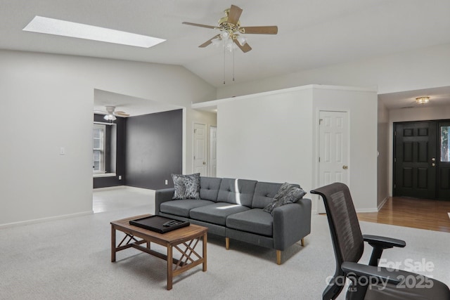 living room featuring ceiling fan and lofted ceiling with skylight