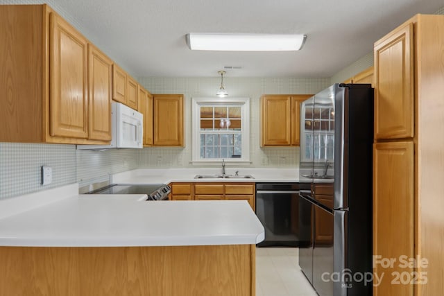 kitchen featuring kitchen peninsula, decorative light fixtures, stainless steel appliances, tasteful backsplash, and sink