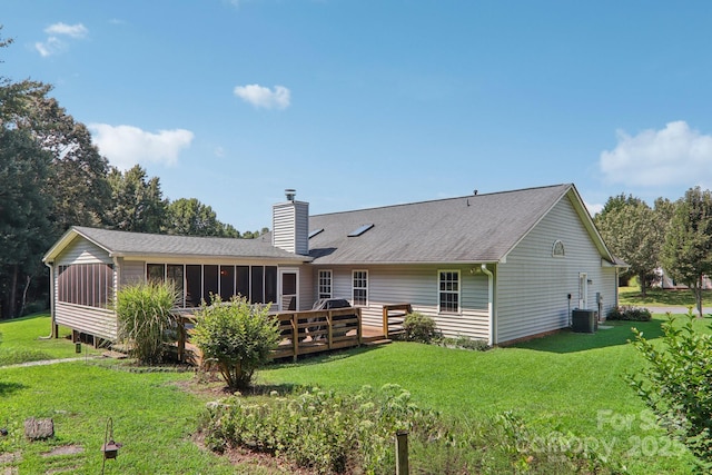 back of house featuring central AC, a deck, a lawn, and a sunroom