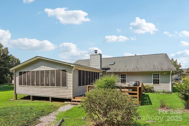 back of property with a deck, a sunroom, and a lawn