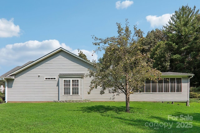 back of property with a yard and a sunroom