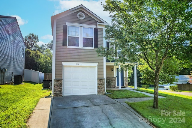 view of front of property with a garage, central AC unit, and a front lawn