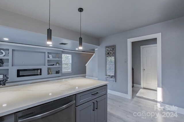 kitchen featuring gray cabinetry, light hardwood / wood-style floors, light stone counters, dishwasher, and decorative light fixtures