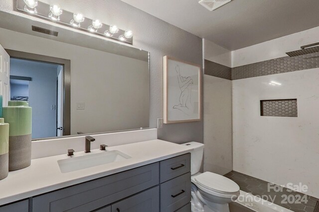 bathroom with a shower, toilet, and vanity