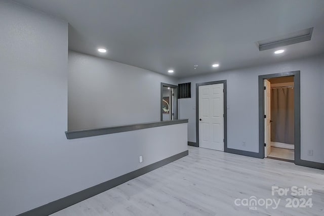 unfurnished room with baseboards, light wood finished floors, and recessed lighting