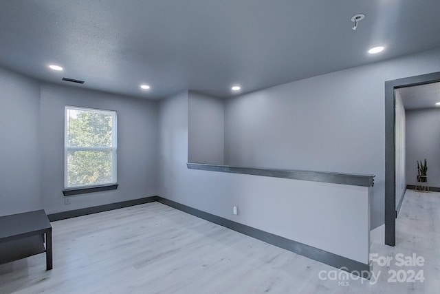 interior space featuring recessed lighting, baseboards, visible vents, and light wood finished floors