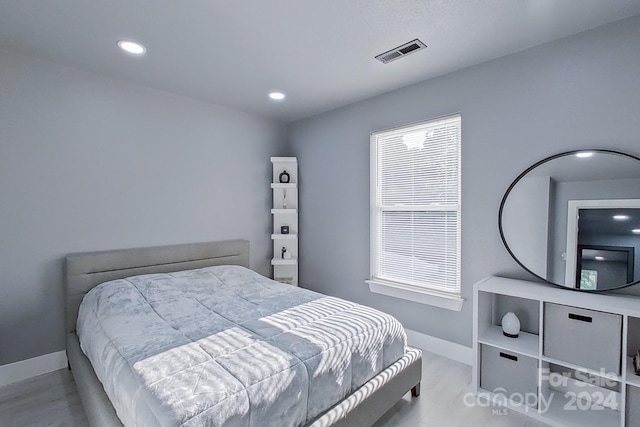 bedroom featuring light wood-style flooring, visible vents, baseboards, and recessed lighting